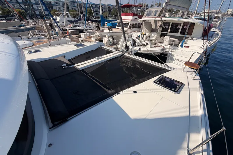 Slide: The Image of 2020 Lagoon 42 catamaran docked at marina, surrounded by other boats. - 15