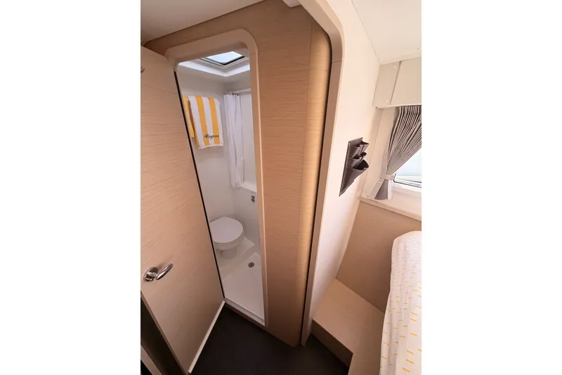 Slide: The Image of Interior of 2020 Lagoon 42 yacht featuring a compact bathroom and cozy cabin space. - 72