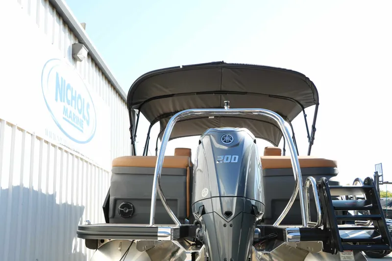 Slide: The Image of The image shows a Bennington 23 MFB Tri Toon boat with a large outboard motor. - 23