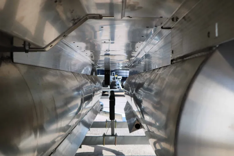 Slide: The Image of Underside view of a Bennington 23 MFB Tri Toon with aluminum hulls on a trailer. - 28