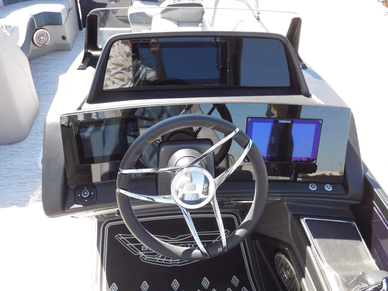 Slide: The Image of The image shows the helm of a Bennington 25 QXFBA boat with modern instruments. - 22