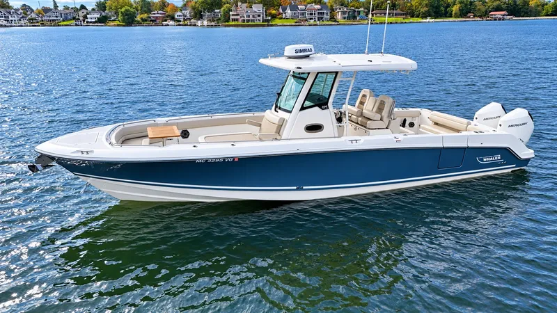 Slide: The Image of Boston Whaler 330 Outrage 2024 on calm water, featuring a blue hull and white deck. - 35