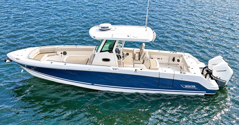 Slide: The Image of A 2024 Boston Whaler 330 Outrage on calm water, featuring a blue hull and white upper deck. - 34