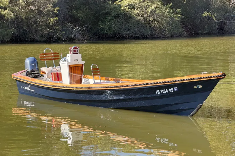 Slide: The Image of 2019 Caribiana Maracas 23 Skiff on calm water, featuring sleek design and outboard motor. - 9
