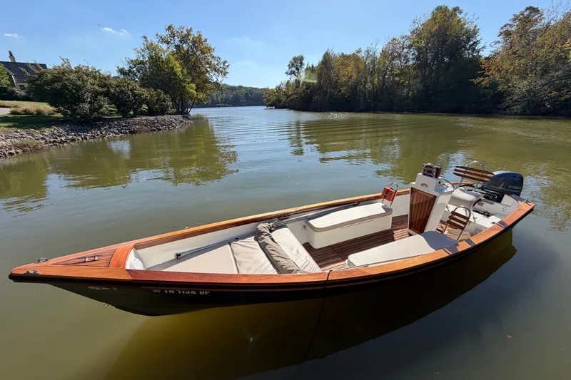 Slide: The Image of 2019 Caribiana Maracas 23 Skiff on calm river, surrounded by trees. - 3