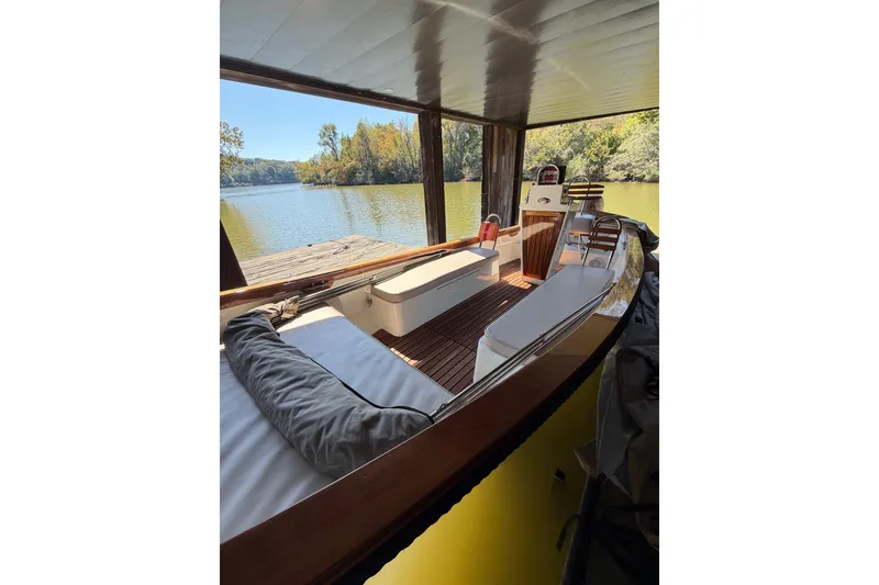 Slide: The Image of 2019 Caribiana Maracas 23 Skiff docked on a serene lake with lush surroundings. - 4