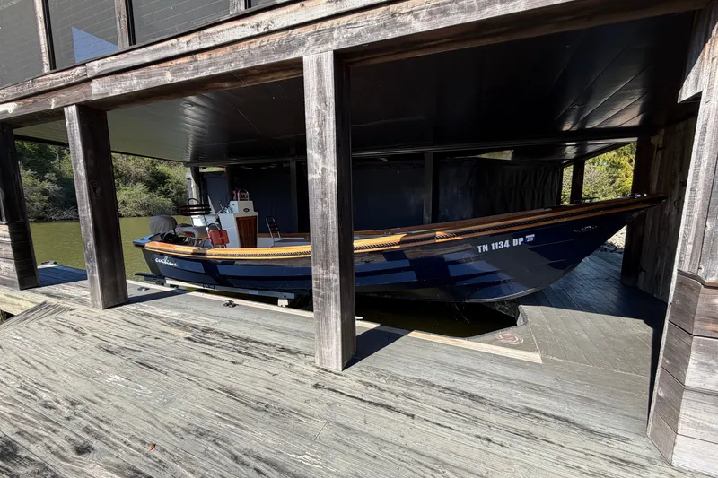 Slide: The Image of 2019 Caribiana Maracas 23 Skiff docked in a wooden boathouse. - 2