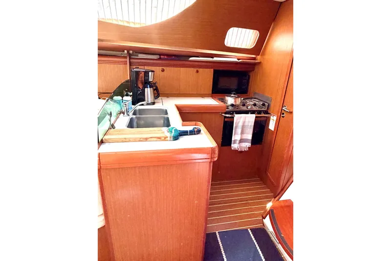 Slide: The Image of Interior view of 2007 Jeanneau Sun Odyssey 42 DS yacht kitchen with wooden cabinetry. - 13