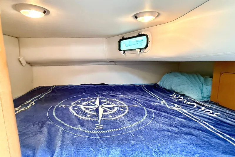 Slide: The Image of Cozy cabin interior of 2009 Four Winns 278 Vista with nautical-themed bedding. - 24