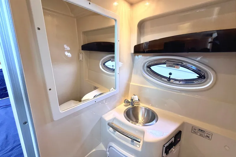 Slide: The Image of 2009 Four Winns 278 Vista boat bathroom with sink, mirror, and oval window. - 27