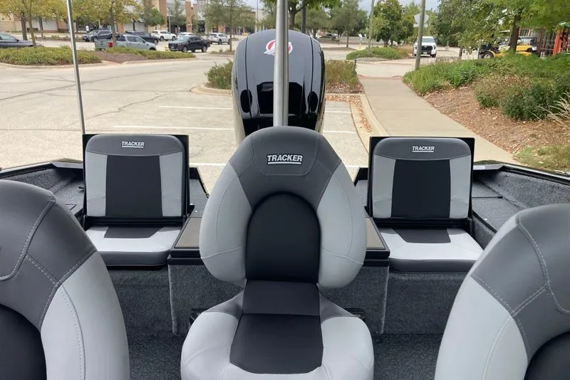 Slide: The Image of 2027 Tracker Targa V-18 Combo boat interior with gray seating in a parking lot. - 59