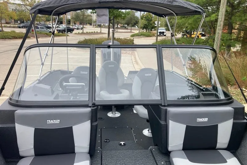 Slide: The Image of 2027 Tracker Targa V-18 Combo boat with seating and windshield, parked outdoors. - 61