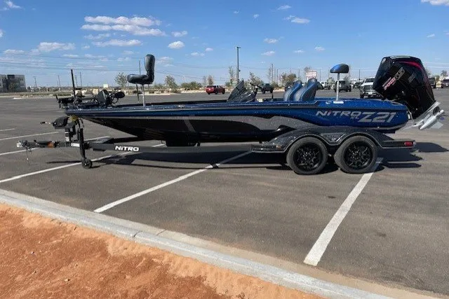 The Image of 2027 Nitro Z21 XL Pro boat in parking lot, sleek design, dual axle trailer. - 0