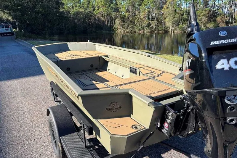 Slide: The Image of 2027 Tracker Grizzly 1553 Timber boat with Mercury 40 engine, parked near a serene lake. - 49