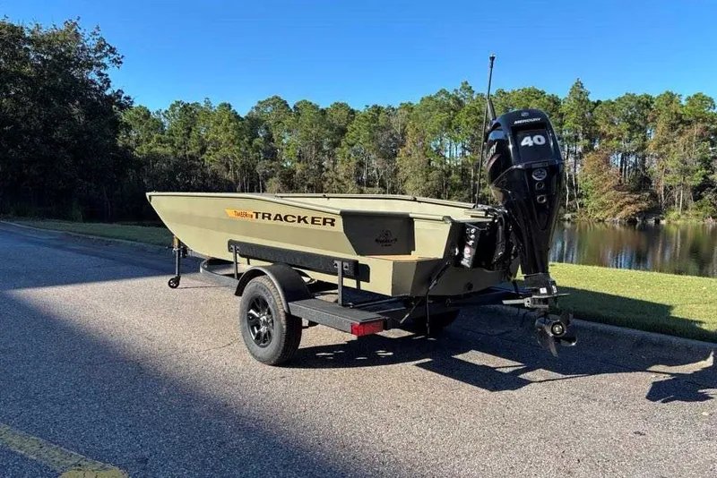 Slide: The Image of 2027 Tracker Grizzly 1553 Timber boat on trailer, parked near a scenic lake. - 50