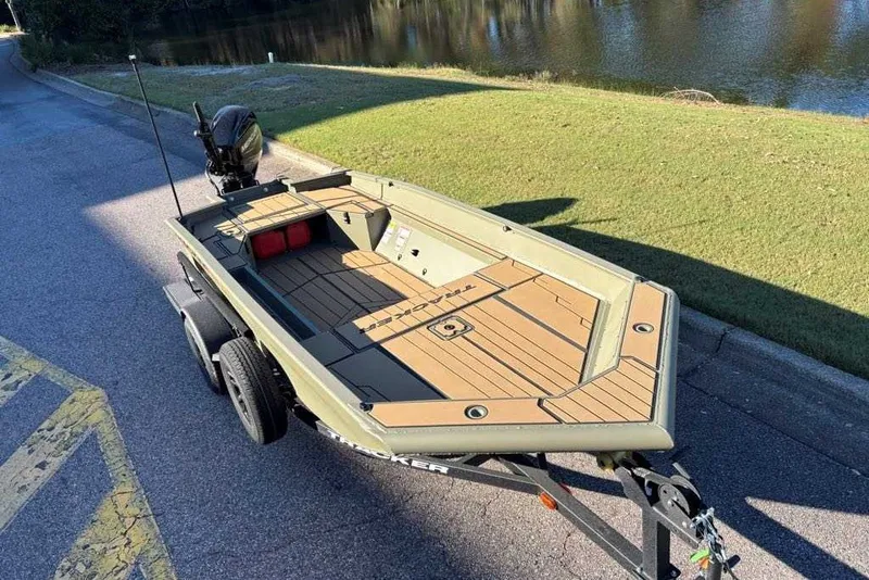 Slide: The Image of 2027 Tracker Grizzly 1553 Timber boat on trailer by a lakeside road. - 13