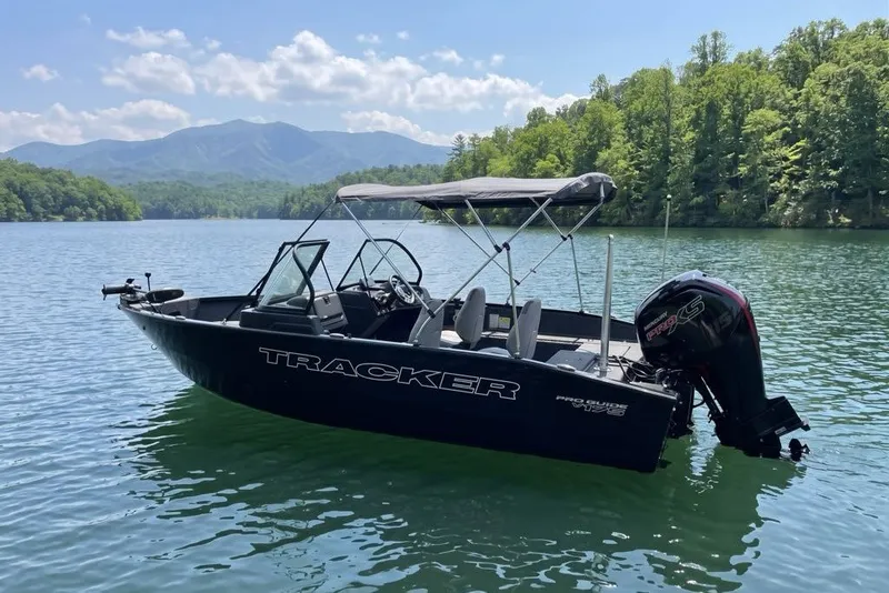 The Image of 2027 Tracker Pro Guide V-175 Combo boat on a scenic lake with mountains. - 11