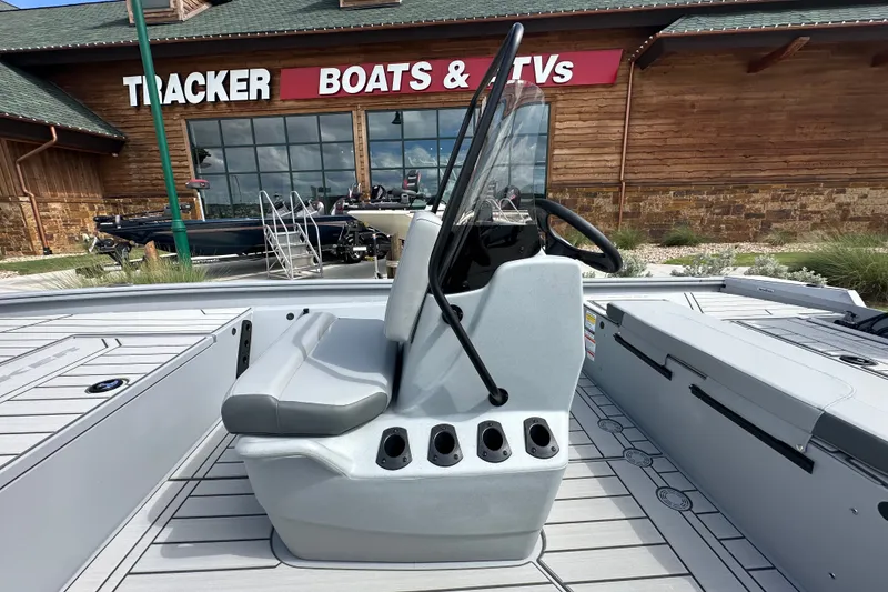 Slide: The Image of 2027 Tracker Bass Tracker 175 CC boat interior at dealership, featuring steering console and seating. - 19