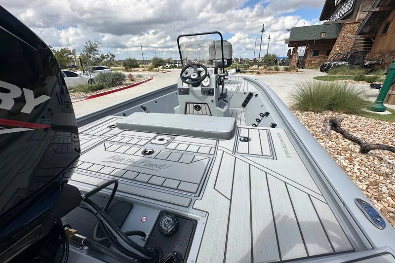 Slide: The Image of 2027 Tracker Bass Tracker 175 CC boat with sleek design, parked outdoors under cloudy sky. - 16