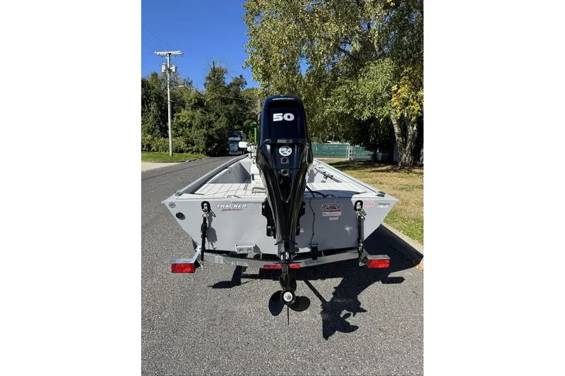 Slide: The Image of 2027 Tracker Bass Tracker Classic CC boat with outboard motor on a sunny street. - 18