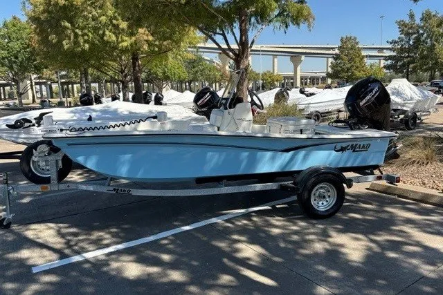 Slide: The Image of 2027 Mako Pro Skiff 15 CC boat on trailer in outdoor parking lot. - 1