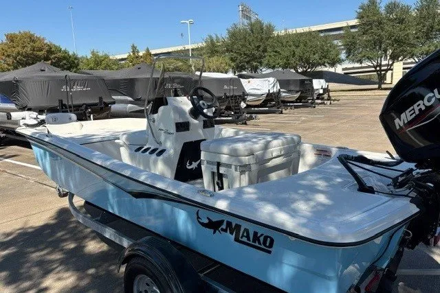 Slide: The Image of 2027 Mako Pro Skiff 15 CC boat in parking lot, featuring a Mercury outboard motor. - 8