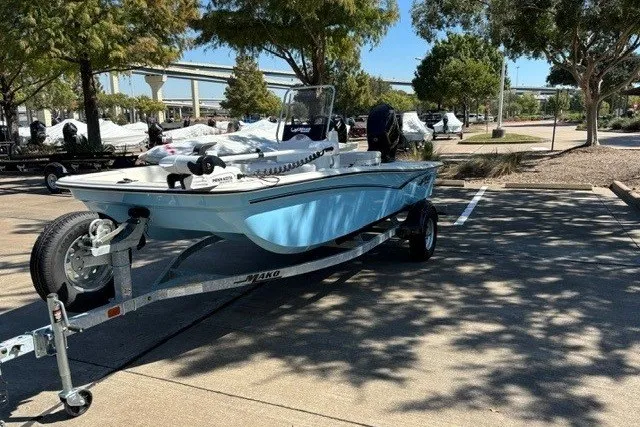 Slide: The Image of 2027 Mako Pro Skiff 15 CC boat on trailer in parking lot, sunny day. - 4
