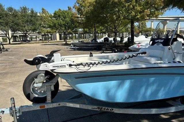 Slide: The Image of 2027 Mako Pro Skiff 15 CC boat on trailer, featuring Minn Kota trolling motor. - 11
