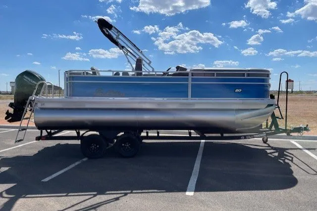 Slide: The Image of 2027 Sun Tracker SportFish 20 DLX pontoon boat parked under a clear blue sky. - 13