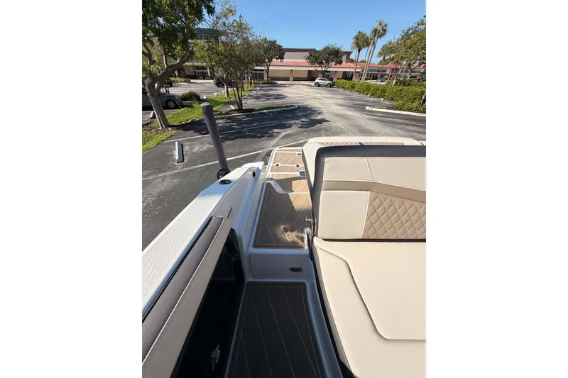Slide: The Image of 2024 MONTERY 278ss boat interior with beige seating in a parking lot setting. - 19