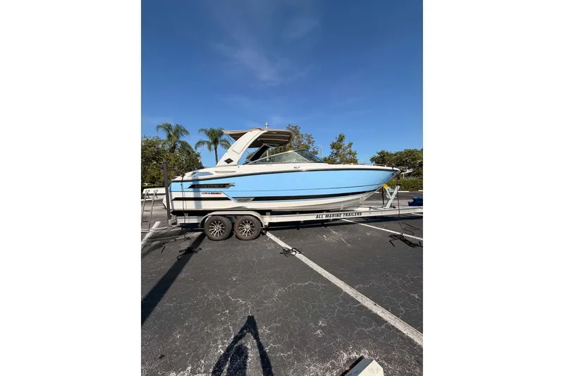 Slide: The Image of 2024 MONTERY 278ss boat on trailer, parked outdoors under clear blue sky. - 24