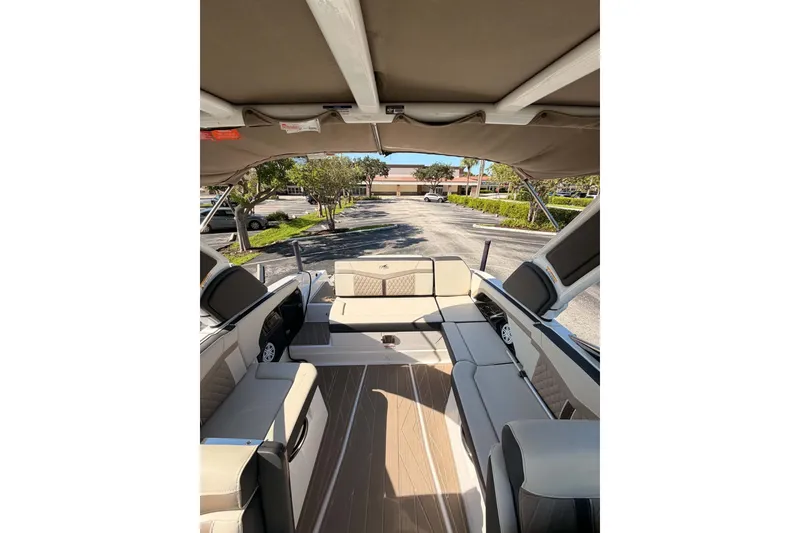 Slide: The Image of 2024 MONTERY 278ss boat interior with beige seating and canopy in a parking lot. - 14