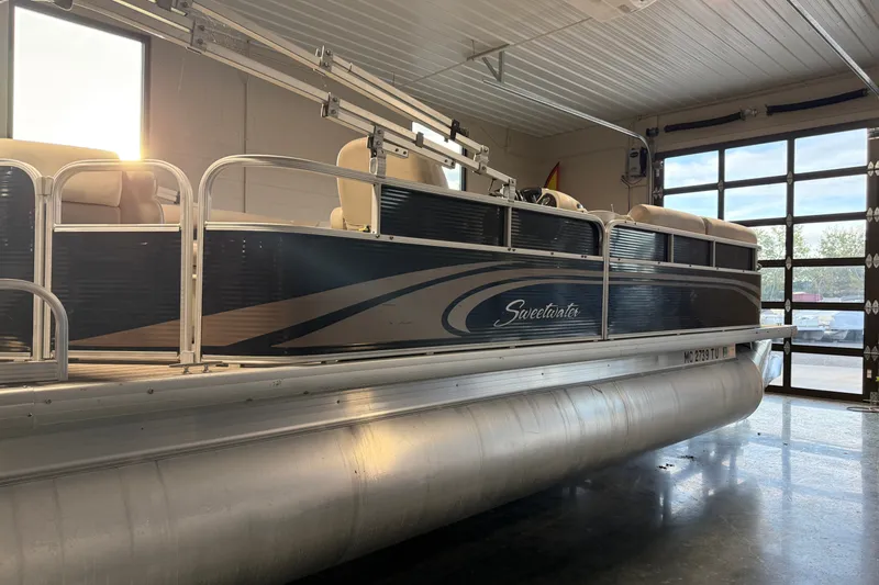 Slide: The Image of 2014 Sweetwater 2286 pontoon boat in a garage with sunlight streaming in. - 16