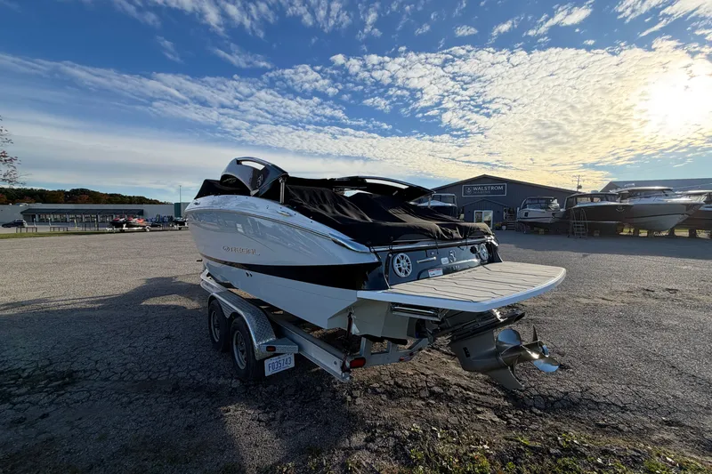 Slide: The Image of 2020 Regal LS4 boat on trailer under a vibrant sky at a marina. - 18