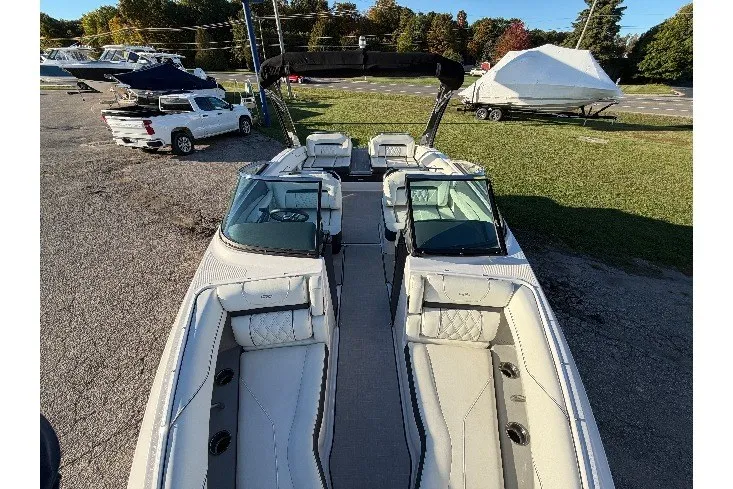Slide: The Image of 2020 Regal LS4 boat with spacious seating, parked outdoors on a sunny day. - 23