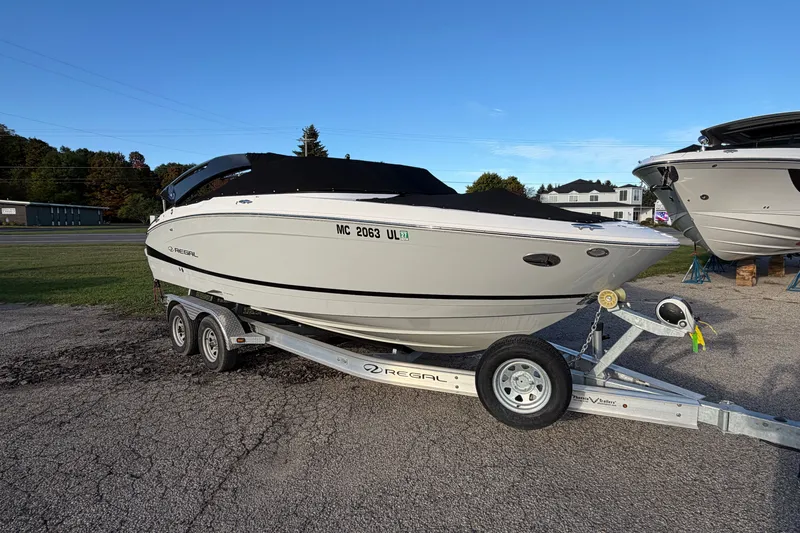 Slide: The Image of 2020 Regal LS4 boat on trailer, parked outdoors under clear blue sky. - 16