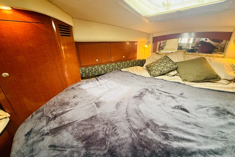 Slide: The Image of Luxurious cabin interior of 2005 Sea Ray 340 Sundancer with plush bedding and wood accents. - 61