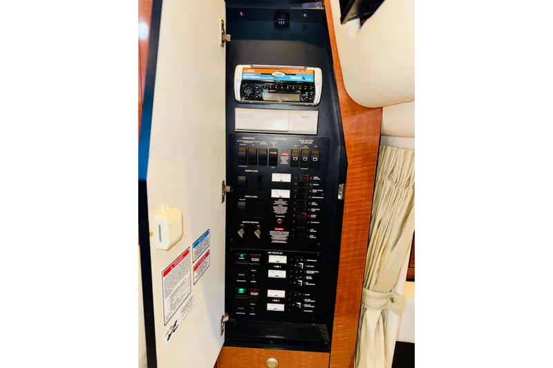 Slide: The Image of Electrical panel inside a 2005 Sea Ray 340 Sundancer boat, featuring various switches and controls. - 74