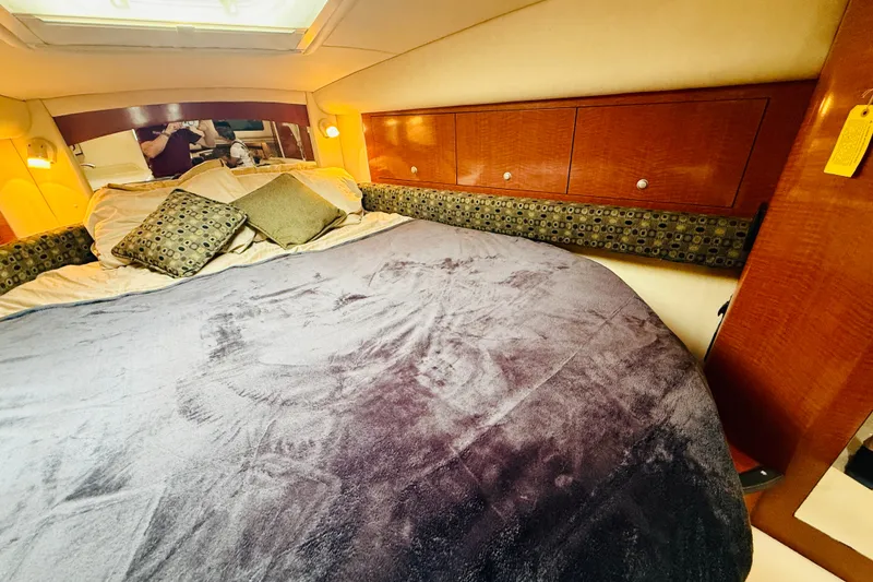 Slide: The Image of Luxurious cabin interior of 2005 Sea Ray 340 Sundancer with plush bedding and wooden cabinetry. - 62