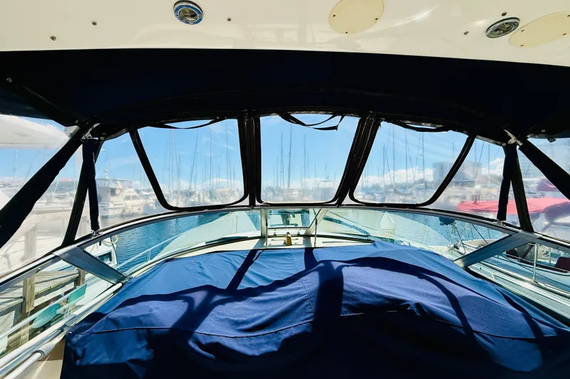 Slide: The Image of 2005 Sea Ray 340 Sundancer cockpit with marina view, featuring blue canvas cover. - 38