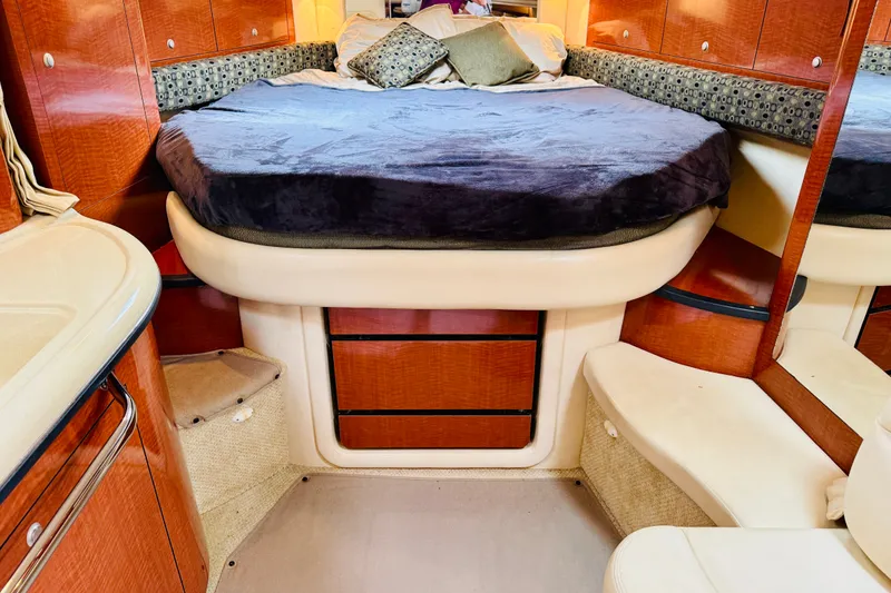 Slide: The Image of 2005 Sea Ray 340 Sundancer cabin interior with cozy bed and wooden cabinetry. - 60