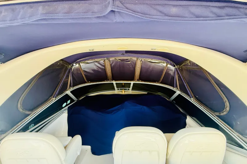 Slide: The Image of 2005 Sea Ray 340 Sundancer cockpit with blue canopy and white seating. - 36