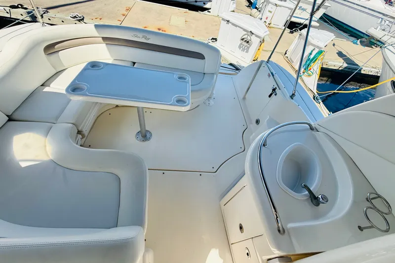 Slide: The Image of 2005 Sea Ray 340 Sundancer cockpit with seating, table, and sink at marina. - 28