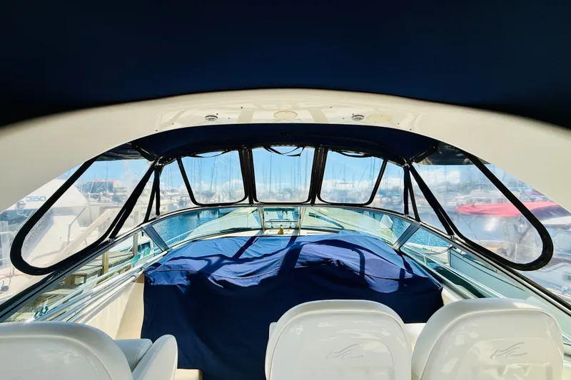 Slide: The Image of 2005 Sea Ray 340 Sundancer cockpit with covered seating, marina view through windows. - 40