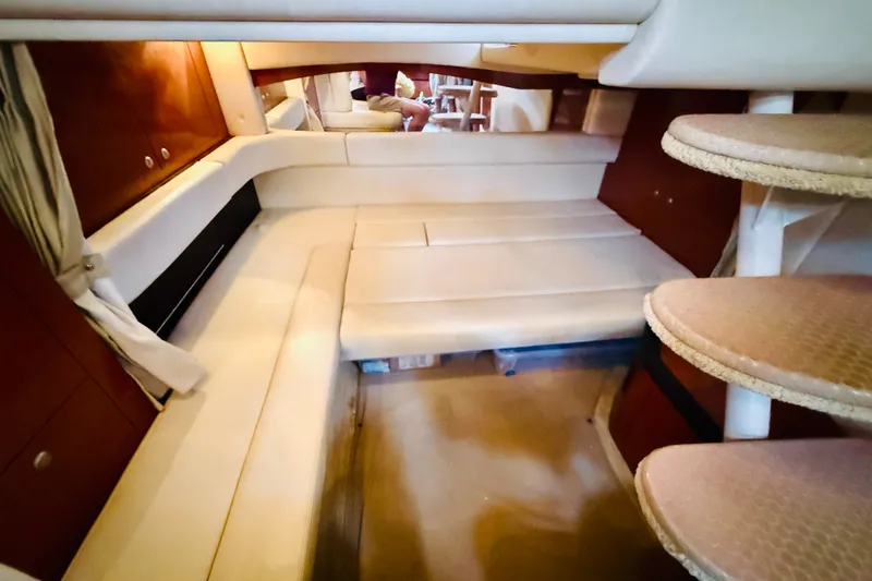 Slide: The Image of 2005 Sea Ray 340 Sundancer cabin interior with beige seating and wooden accents. - 48
