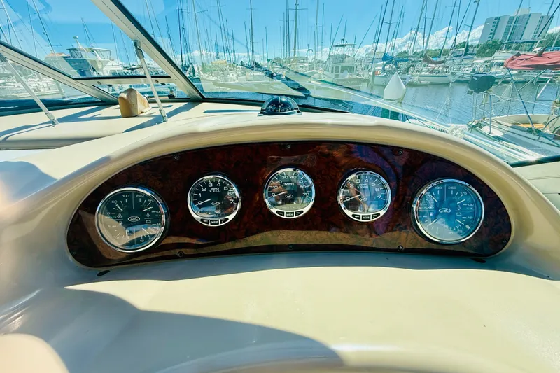 Slide: The Image of Dashboard of a 2005 Sea Ray 340 Sundancer boat with marina view. - 12