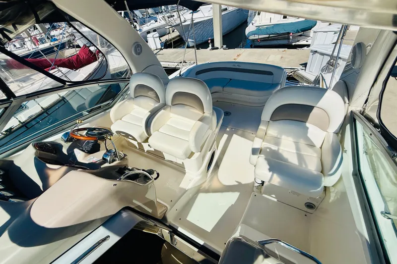 Slide: The Image of 2005 Sea Ray 340 Sundancer cockpit with plush seating and sleek design at marina. - 30