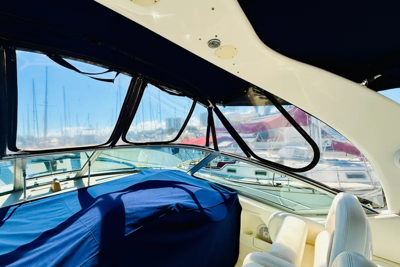 Slide: The Image of Interior view of 2005 Sea Ray 340 Sundancer yacht with covered seating and marina backdrop. - 37