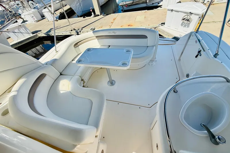 Slide: The Image of 2005 Sea Ray 340 Sundancer cockpit with white seating and table at marina. - 29