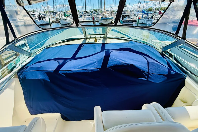 Slide: The Image of 2005 Sea Ray 340 Sundancer boat interior with blue cover, docked at marina. - 41